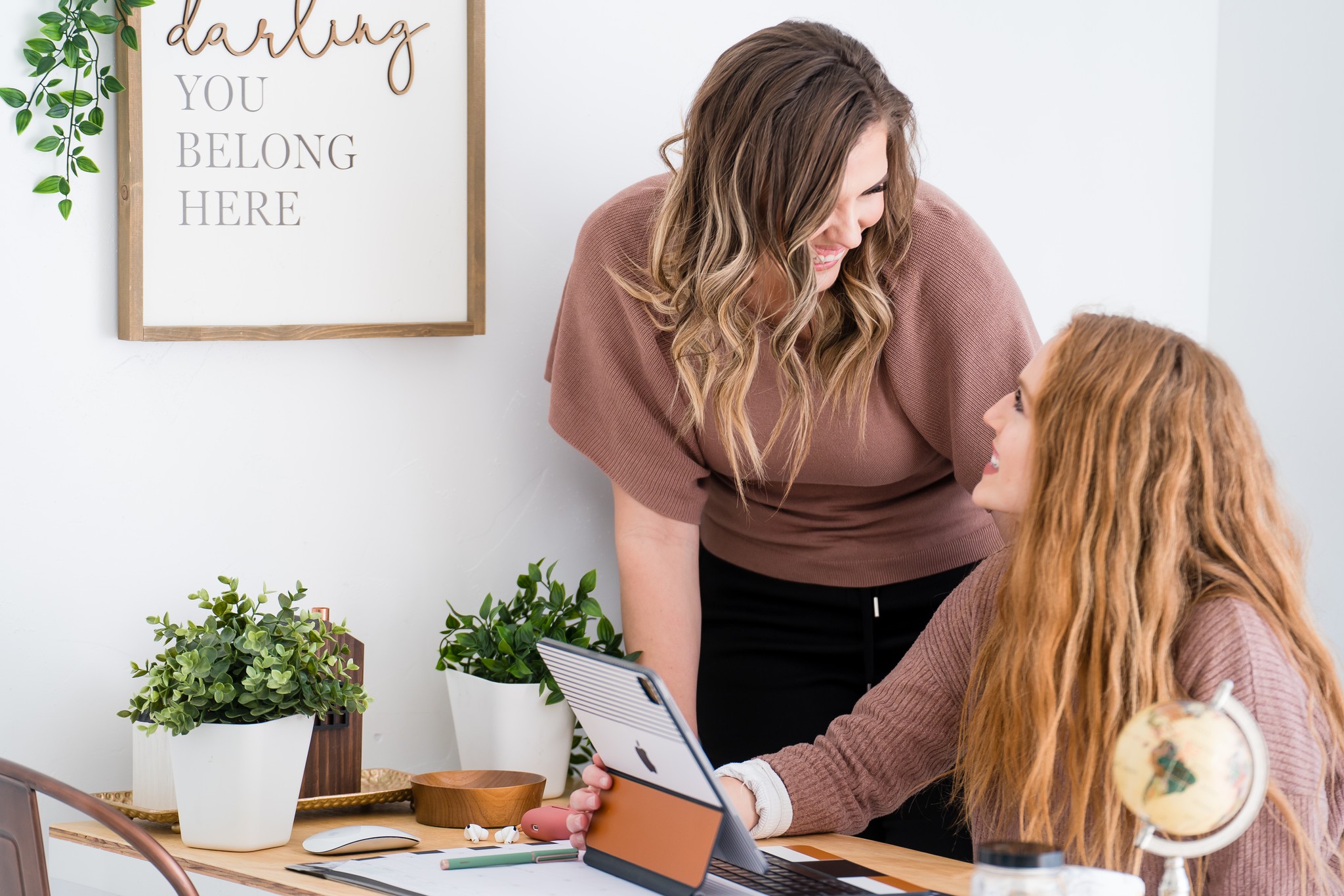 Mindset coaching women entrepreneurs, teila marie and client work together at desk smiling